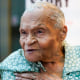 Viola Fletcher places her hand on her chest while speaking